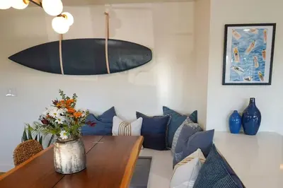 a living room with a table with a vase of flowers at Sunset View home 2 min walk to beach parking in San Diego