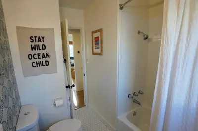 a bathroom with a white toilet and a shower at Sunset View home 2 min walk to beach parking in San Diego