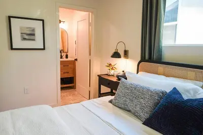 a bedroom with a bed with blue pillows and a window at Sunset View home 2 min walk to beach parking in San Diego