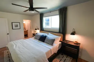 a bedroom with a large bed with a ceiling fan at Sunset View home 2 min walk to beach parking in San Diego