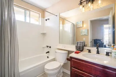 a bathroom with a toilet and a sink and a tub at Peaceful Poolside Perfection near Wine Country in Murrieta