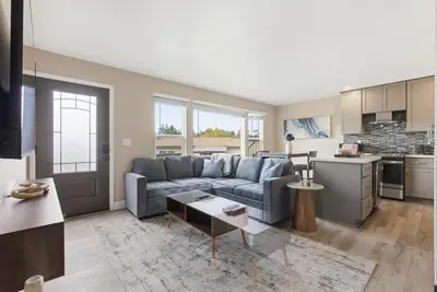 a living room with a couch and a kitchen at New Modern 2BR Home with Movie theater, & Big Yard in La Mesa