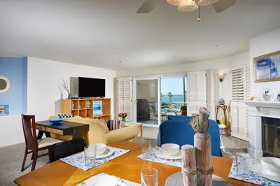 a living room with a table and a fireplace at 4P-201 Ocean View Steps to Beach in Oceanside