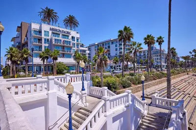 a white fence with palm trees and buildings at 4P-201 Ocean View Steps to Beach in Oceanside