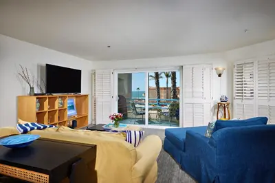 a living room with a blue couch and a tv at 4P-201 Ocean View Steps to Beach in Oceanside