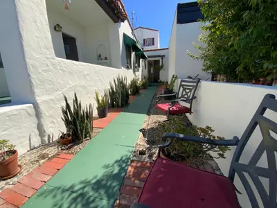 a walkway with benches and plants in front of a building at Casa Cabrillo in San Clemente