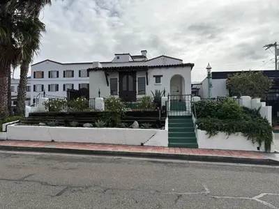 a white house with a green staircase in front of it at Casa Cabrillo in San Clemente