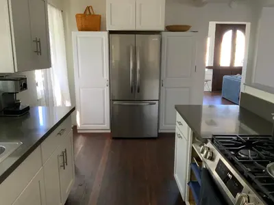 a kitchen with a stainless steel refrigerator and white cabinets at Casa Cabrillo in San Clemente