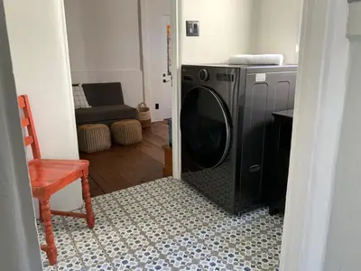 a washing machine in a living room with a chair at Casa Cabrillo in San Clemente