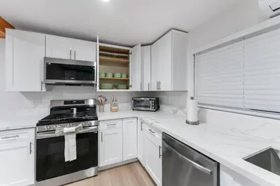 a kitchen with white cabinets and a stove top oven at Luxury Retreat, Foosball, Pool table, NEW Upgrades in Chula Vista