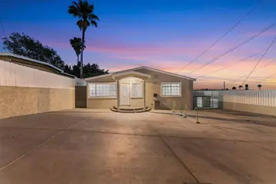 a house in a parking lot with a palm tree at Luxury Retreat, Foosball, Pool table, NEW Upgrades in Chula Vista
