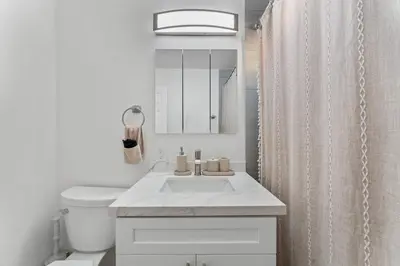 a white bathroom with a sink and a shower at Luxury Retreat, Foosball, Pool table, NEW Upgrades in Chula Vista