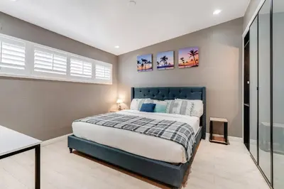 a bedroom with a large bed with a blue headboard at Spacious 4BR w/ Pool, Spa, Mini Golf & Game Lounge in Chula Vista