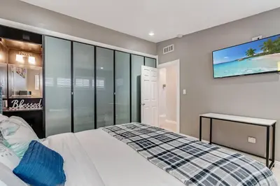 a bedroom with a bed and a tv on the wall at Spacious 4BR w/ Pool, Spa, Mini Golf & Game Lounge in Chula Vista