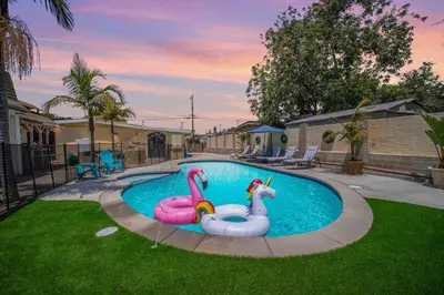 two inflatable flamingos in a pool in a yard at Spacious 4BR w/ Pool, Spa, Mini Golf & Game Lounge in Chula Vista
