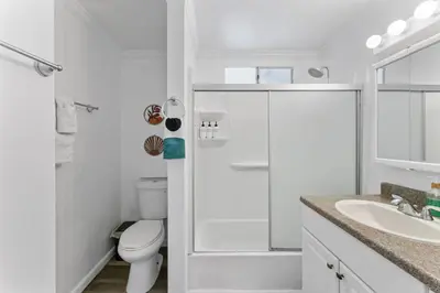 a white bathroom with a toilet and a sink at 3BR Home w/Big Yard, Close to Shops & Attractions in San Diego