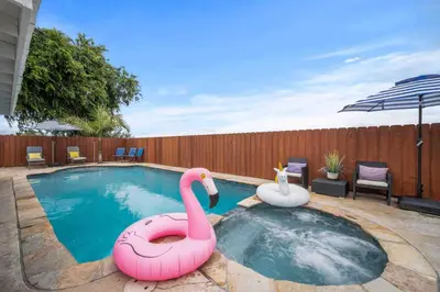 two inflatable flamingos in a pool in a backyard at Family Retreat w/ Theater, Pool & Outdoor Dining in Chula Vista