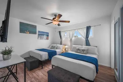 a bedroom with two beds and a ceiling fan at Family Retreat w/ Theater, Pool & Outdoor Dining in Chula Vista