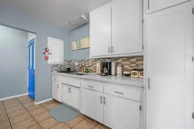 a kitchen with white cabinets and a blue wall at Family Retreat w/ Theater, Pool & Outdoor Dining in Chula Vista