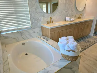 a bathroom with a tub and a sink and a mirror at Modern Residence with Mountain Views in Escondido