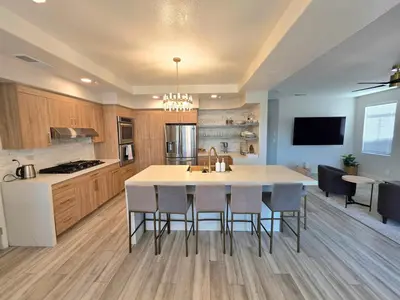 a kitchen with a large white island in a kitchen with chairs at Modern Residence with Mountain Views in Escondido