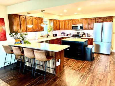 a kitchen with wooden cabinets and a kitchen island with bar stools at Cahuilla Mountain Retreat in Anza