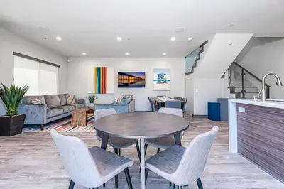 a kitchen and living room with a table and chairs at 8Br Retreat With Ac, Modern Upgrades, And Two Rooftop Decks By Beachview Rentals in Newport Beach