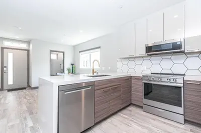a kitchen with stainless steel appliances and wooden cabinets at 8Br Retreat With Ac, Modern Upgrades, And Two Rooftop Decks By Beachview Rentals in Newport Beach