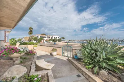 a walkway with plants and flowers and a gate at Bayfront 4Br Retreat With Stunning Newport Harbor Views By Beachview Rentals in Newport Beach