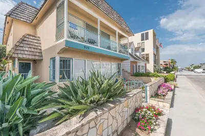 a building with a balcony and some plants at Bayfront 4Br Retreat With Stunning Newport Harbor Views By Beachview Rentals in Newport Beach
