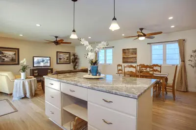a kitchen and living room with a large island at Bayfront 4Br Retreat With Stunning Newport Harbor Views By Beachview Rentals in Newport Beach