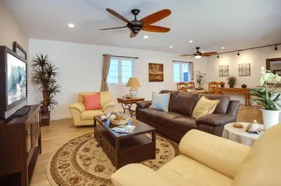 a living room with a couch and a ceiling fan at Bayfront 4Br Retreat With Stunning Newport Harbor Views By Beachview Rentals in Newport Beach