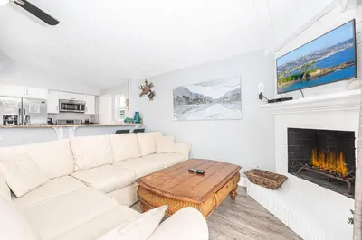 a living room with a white couch and a fireplace at 4Br Coastal Getaway Between The Bay And The Beach By Beachview Rentals in Newport Beach