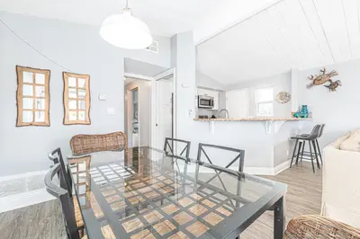 a dining room and living room with a glass table at 4Br Coastal Getaway Between The Bay And The Beach By Beachview Rentals in Newport Beach