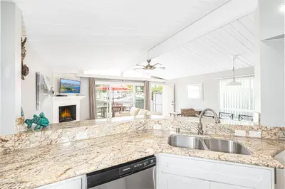 a kitchen with a sink and a fireplace at 4Br Coastal Getaway Between The Bay And The Beach By Beachview Rentals in Newport Beach