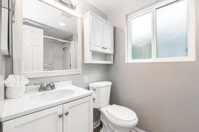 a white bathroom with a toilet and a sink at 4Br Coastal Getaway Between The Bay And The Beach By Beachview Rentals in Newport Beach