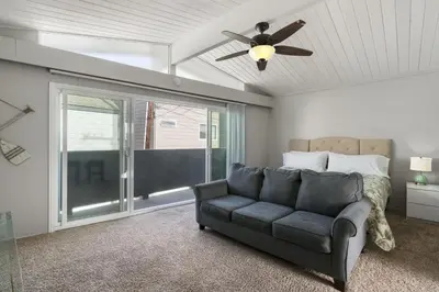 a living room with a couch and a ceiling fan at 4Br Coastal Getaway Between The Bay And The Beach By Beachview Rentals in Newport Beach
