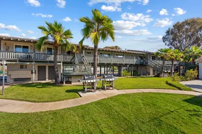 a building with two benches and palm trees at Carlsbad Coastal Retreat in Carlsbad