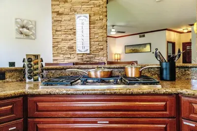 a kitchen with a stove with two pots on it at Oceanside Tropical Resort with HEATED POOL & SPA! in Oceanside