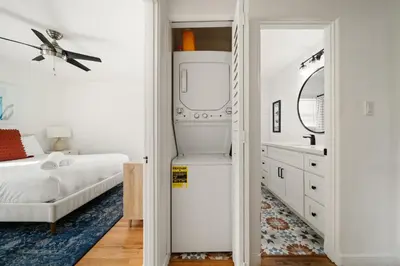 a bedroom with a refrigerator and a bed and a mirror at Little Italy Home with Parking and Backyard in San Diego