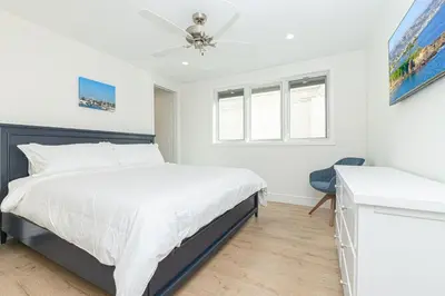 a bedroom with a bed and a ceiling fan at Remodeled Oceanfront Home On The Boardwalk By Beachview Rentals in Newport Beach
