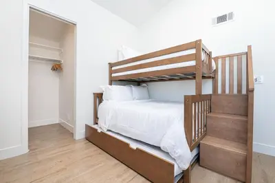 a bedroom with a bunk bed and a staircase at Remodeled Oceanfront Home On The Boardwalk By Beachview Rentals in Newport Beach