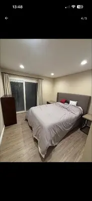 a bedroom with a large bed and two windows at Nice home in Irvine