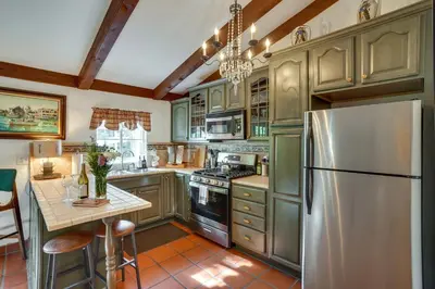 a kitchen with green cabinets and a stainless steel refrigerator at Romantic Retreat at Rancho Las Lomas Pet Friendly