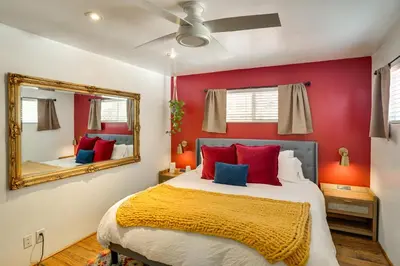a bedroom with a bed with red walls and a mirror at Spacious Courtyard and Spanish Charm Silverado Home