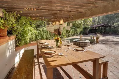 an outdoor dining area with a wooden table and a patio at Spacious Courtyard and Spanish Charm Silverado Home