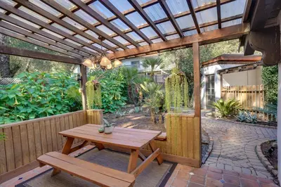 a patio with a wooden table and a wooden pergola at Creative SoCal Escape! Trabuco Canyon Casita