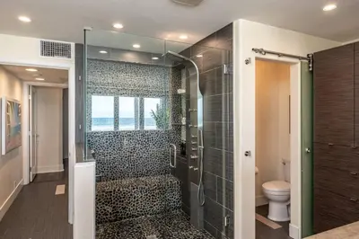 a bathroom with a glass shower with a toilet at Casa Azul at Mission Beach Oceanfront Getaway in San Diego