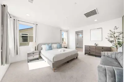 a white bedroom with a bed and a couch at Marbella Lane - Curated 5BR in Upscale RMV Haven in Ladera Ranch