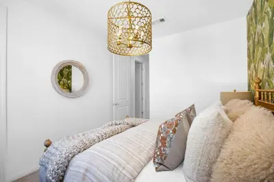 a bedroom with a bed with pillows and a chandelier at Marbella Lane - Stylish Dream Home in RMV w Pool in Mission Viejo
